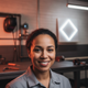A smiling woman welder in her early 30s, with a diverse background, looks directly at the viewer, conveying satisfaction and 